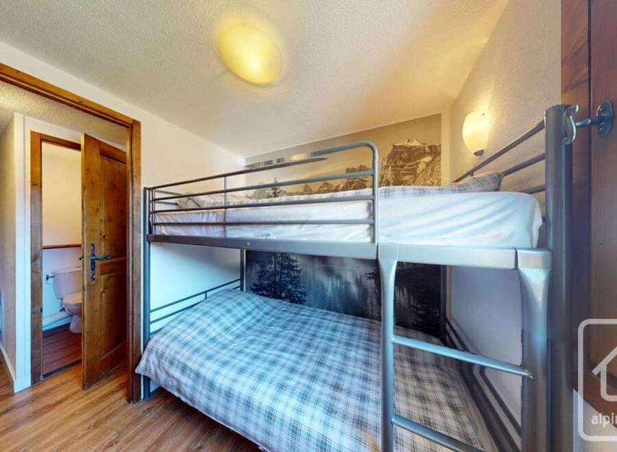 This cozy bedroom features a bunk bed, perfect for accommodating guests or family members.