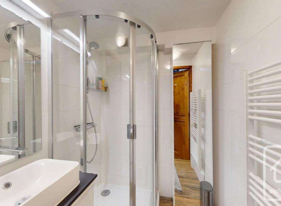 This modern bathroom features a sleek, curved glass shower enclosure, offering a spa-like experience.