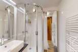This modern bathroom features a sleek, curved glass shower enclosure, offering a spa-like experience.