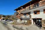 Discover a charming alpine property with stunning wooden balconies and a welcoming entrance.