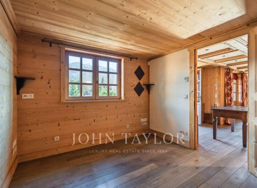 Step into this inviting space, showcasing a warm wooden interior and a bright window offering scenic views.