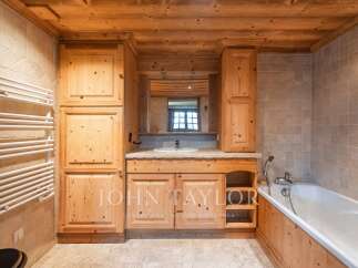 This stunning bathroom boasts a rustic charm with its wooden cabinetry and paneling, creating a warm and inviting atmosphere.