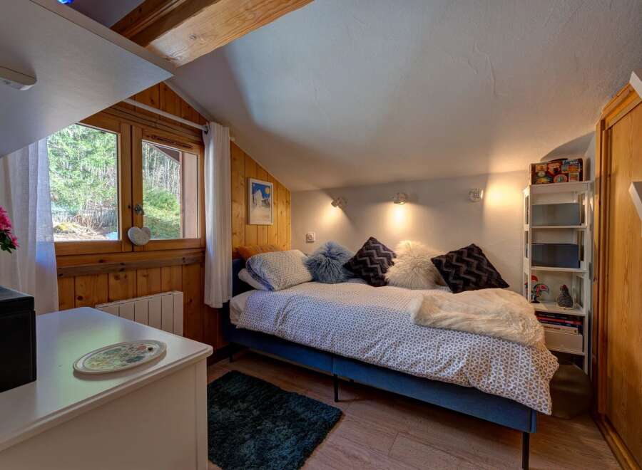 This cozy bedroom features a comfortable bed with decorative pillows and a soft throw, perfect for a relaxing retreat.