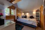 This cozy bedroom features a comfortable bed with decorative pillows and a soft throw, perfect for a relaxing retreat.