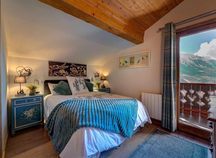 Experience the charm of this cozy bedroom, featuring a plush blue blanket and a comfortable bed.