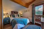Experience the charm of this cozy bedroom, featuring a plush blue blanket and a comfortable bed.