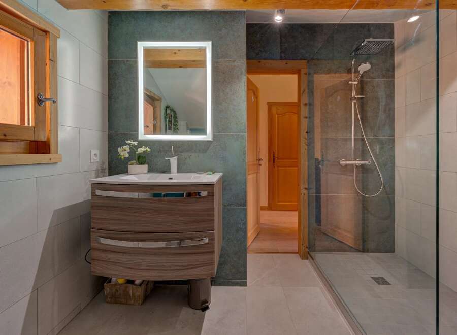 Step into this beautifully designed bathroom, featuring a modern vanity with ample storage and a sleek, illuminated mirror.