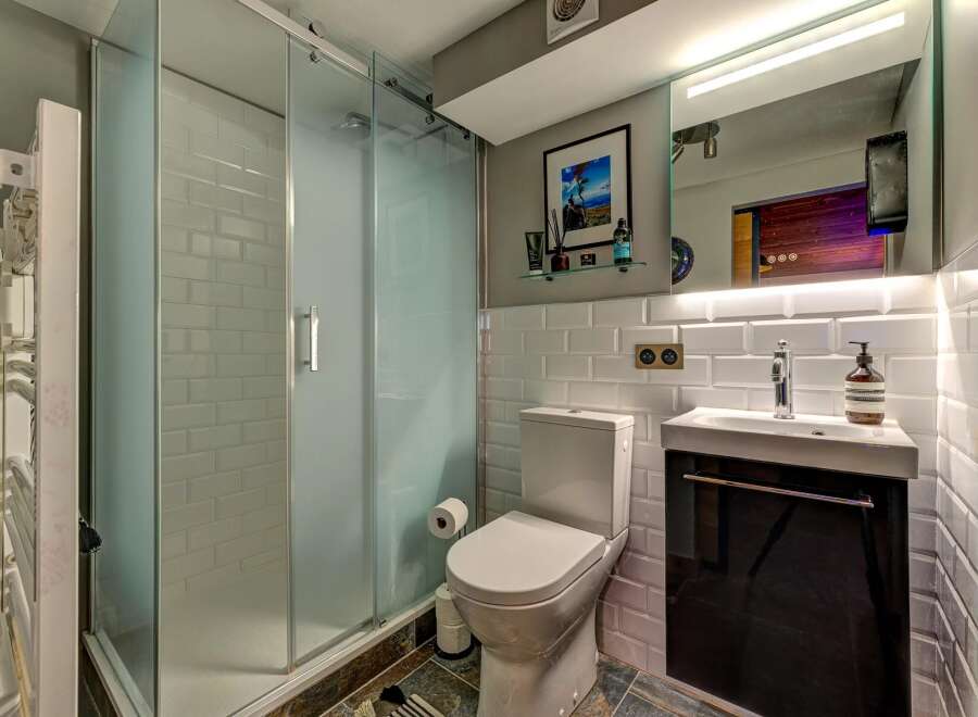 Step into this modern bathroom, featuring a sleek glass shower enclosure and stylish subway tile accents.