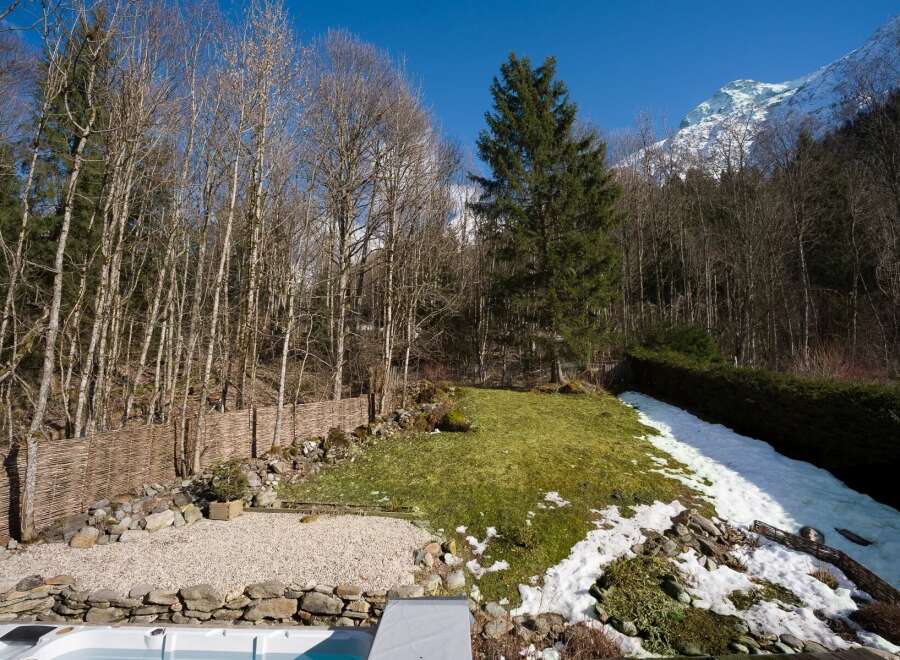 Escape to your own private oasis with this stunning property! Enjoy the tranquility of nature with a lush green lawn, a serene hot tub, and a backdrop of majestic mountains.