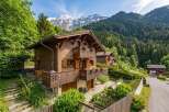 Experience alpine living in this charming wooden chalet nestled amidst lush greenery and majestic snow-capped mountains.