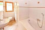 This inviting bathroom features a bright, airy design with pristine white tiles and a relaxing bathtub.