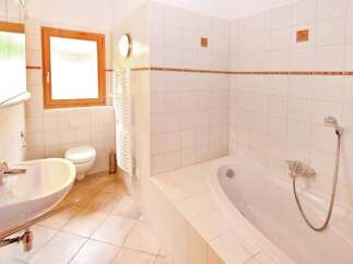 This inviting bathroom features a bright, airy design with pristine white tiles and a relaxing bathtub.