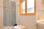 This bathroom features a modern shower with glass doors, providing a sleek and functional space.