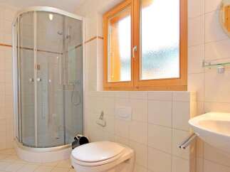 This bathroom features a modern shower with glass doors, providing a sleek and functional space.