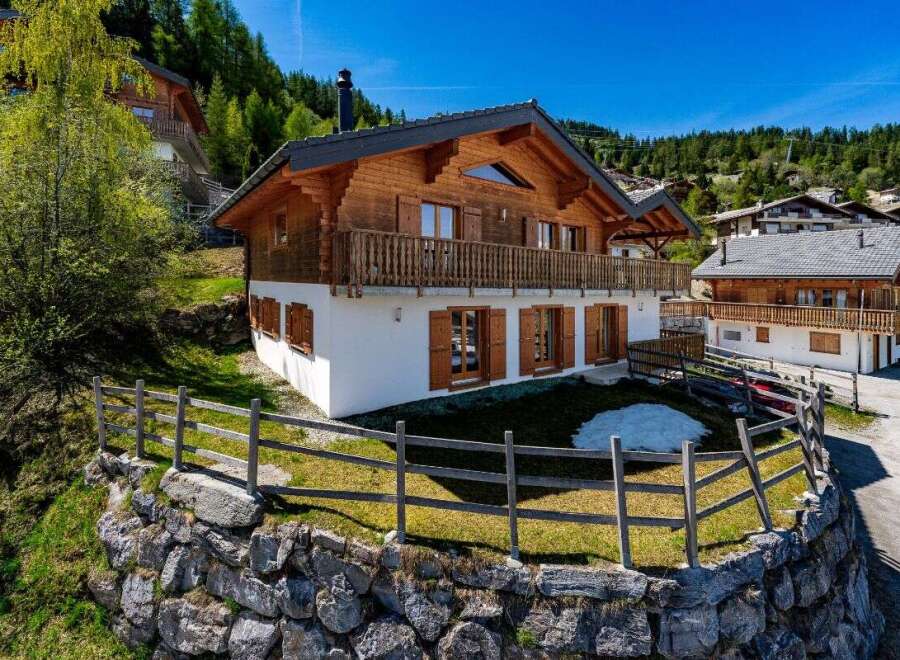 Experience alpine living in this stunning wooden chalet, nestled on a hillside with breathtaking mountain views.