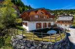Experience alpine living in this stunning wooden chalet, nestled on a hillside with breathtaking mountain views.