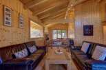 Experience rustic charm in this cozy living room, featuring warm wood paneling and exposed beams.