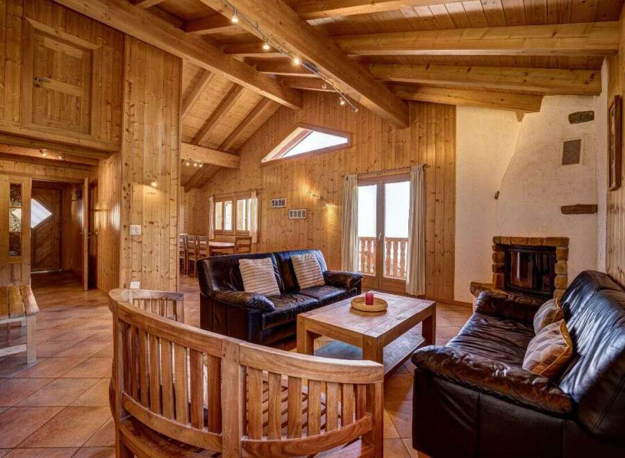 Experience rustic charm in this inviting living space, featuring a cozy fireplace and rich wood paneling throughout.