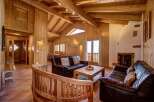 Experience rustic charm in this inviting living space, featuring a cozy fireplace and rich wood paneling throughout.