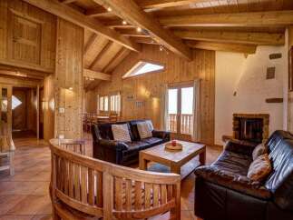 Experience rustic charm in this inviting living space, featuring a cozy fireplace and rich wood paneling throughout.