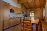 Experience cozy living in this charming kitchen and dining area, featuring warm wooden cabinetry and a spacious dining table perfect for family meals.