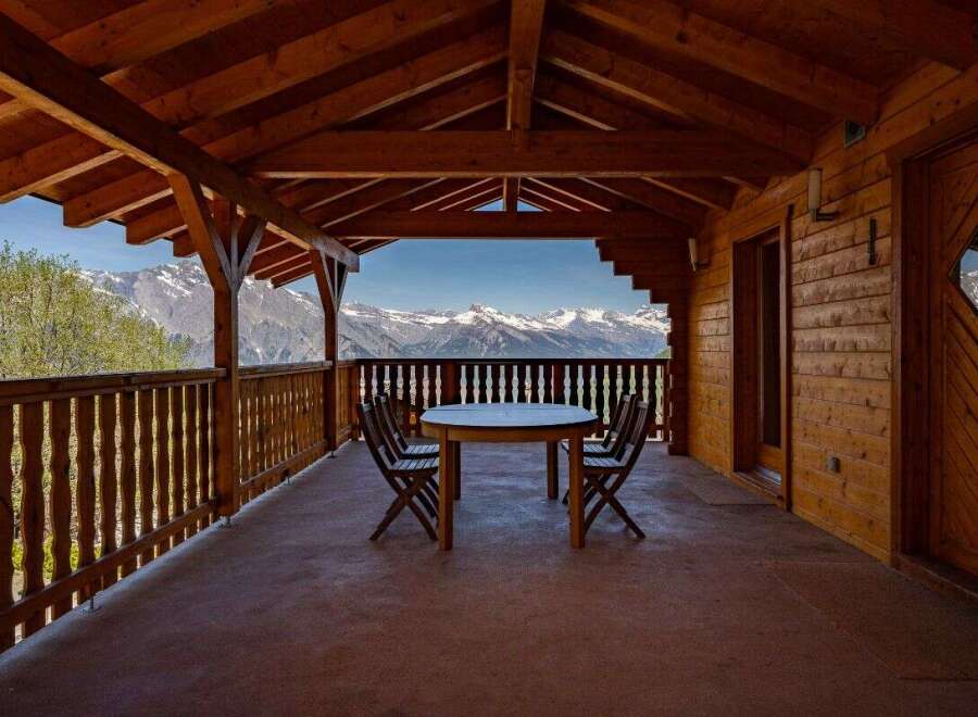 Enjoy breathtaking mountain views from this charming wooden balcony, perfect for al fresco dining or morning coffee.