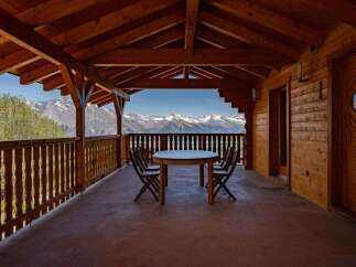 Enjoy breathtaking mountain views from this charming wooden balcony, perfect for al fresco dining or morning coffee.