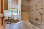 This charming bathroom features a spacious bathtub perfect for relaxing soaks, complemented by a modern sink and toilet.