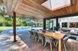 Experience luxury living with this stunning property featuring an outdoor dining area overlooking a sparkling pool.