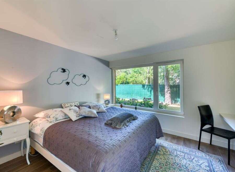This stunning bedroom offers a serene retreat with its modern design and ample natural light.