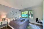 This stunning bedroom offers a serene retreat with its modern design and ample natural light.