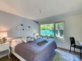 This stunning bedroom offers a serene retreat with its modern design and ample natural light.