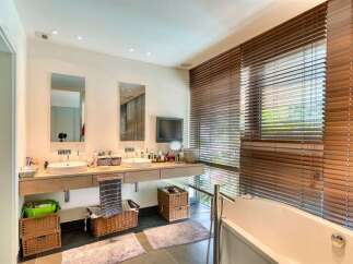 This luxurious bathroom boasts a sleek design with modern fixtures and ample space.