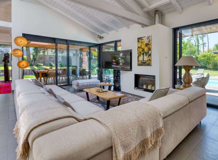 Experience luxury living in this stunning property featuring a spacious living room with a cozy fireplace and a modern TV setup.
