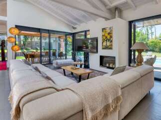 Experience luxury living in this stunning property featuring a spacious living room with a cozy fireplace and a modern TV setup.