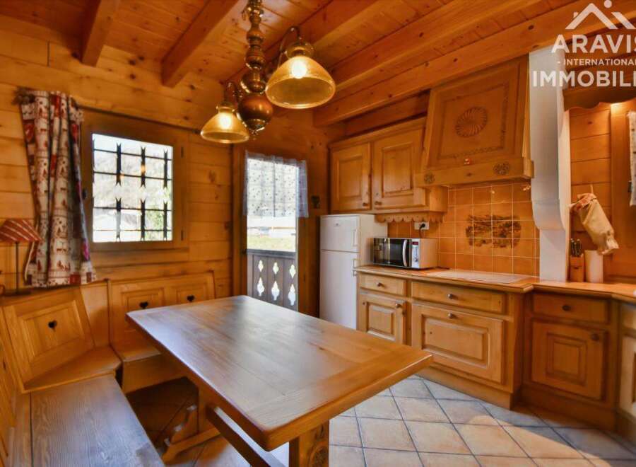 This charming property boasts a cozy, rustic kitchen with wooden cabinetry and a dining area.