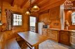 This charming property boasts a cozy, rustic kitchen with wooden cabinetry and a dining area.