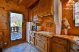 Discover the charm of this cozy kitchen, featuring warm wooden cabinetry and a modern microwave.