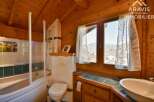 Discover the charm of this cozy bathroom, featuring a unique wooden design that exudes warmth and character.