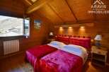 Discover the charm of this cozy bedroom featuring warm wooden accents and a comfortable double bed.