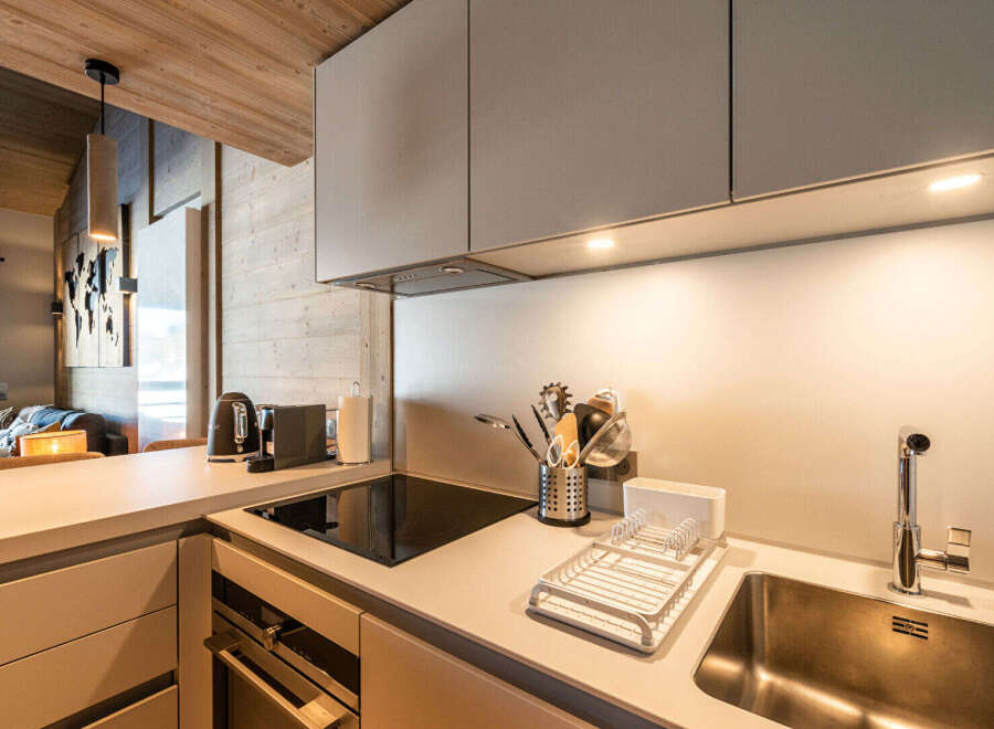 Discover modern living in this stylish kitchen! Featuring sleek cabinetry, a built-in cooktop, and a stainless steel sink, this space is perfect for culinary enthusiasts.