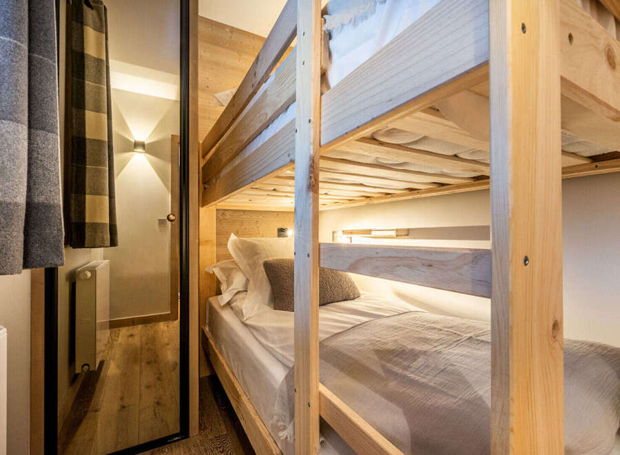 This cozy bedroom features a custom-built bunk bed, perfect for accommodating guests or family.