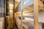 This cozy bedroom features a custom-built bunk bed, perfect for accommodating guests or family.