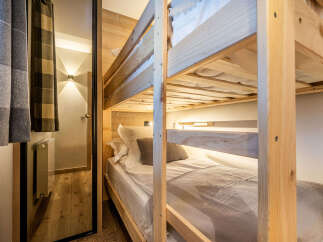 This cozy bedroom features a custom-built bunk bed, perfect for accommodating guests or family.