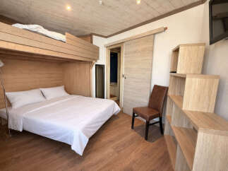 Discover this cozy and stylish bedroom featuring a unique bunk bed design, perfect for maximizing space.