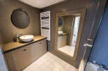 Step into this stylish bathroom, featuring a modern design with a sleek sink and a large mirror.