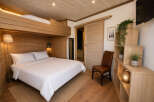 Experience cozy living in this charming room featuring a comfortable queen-sized bed and a unique lofted bunk above.