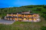 This stunning modern home offers a luxurious living experience with its sleek design and expansive windows.