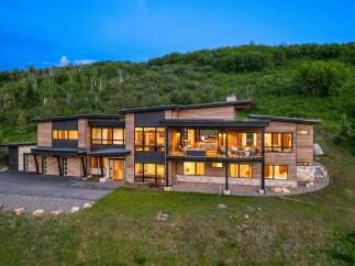 This stunning modern home offers a luxurious living experience with its sleek design and expansive windows.