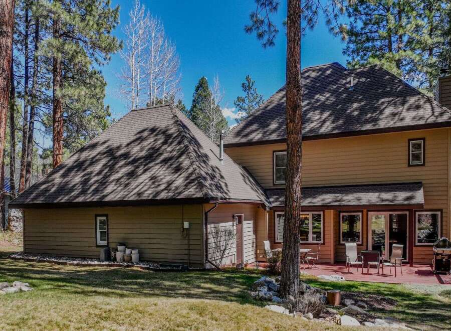 Nestled amidst towering trees, this stunning property boasts a spacious layout and inviting outdoor spaces.